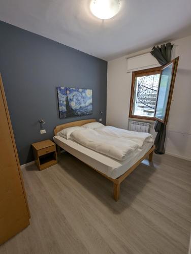 a bedroom with a large bed and a window at Casa Marica - Appartamento nel Borgo di Pieve in Tremosine Sul Garda