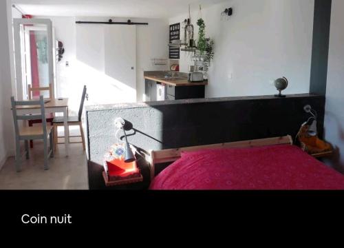 um quarto com uma cama com uma colcha vermelha em Studio indépendant terrasse entre mer et collines em Marselha