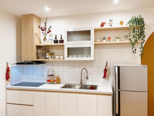a kitchen with a sink and a refrigerator at AmHome Premium Vinhome OceanPark in Hanoi