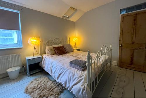 a bedroom with a white bed and a window at Charming cottage retreat with garden - sleeps 12 in Bristol