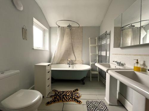 a bathroom with a tub and a toilet and a sink at Charming cottage retreat with garden - sleeps 12 in Bristol