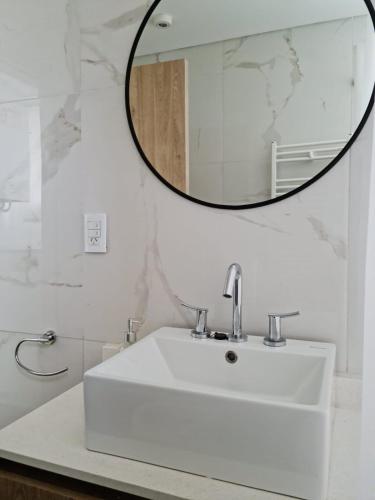 a bathroom with a white sink and a mirror at Sweet Home in Junín