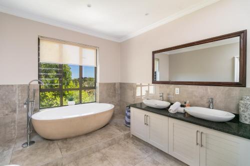 a bathroom with two sinks and a large mirror at Super Beachfront views- Executive Villa - 6 bedrooms in Knysna