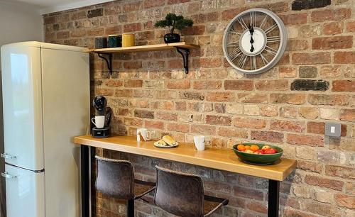a brick wall with a table with a bowl of fruit at Linwood in Lincoln
