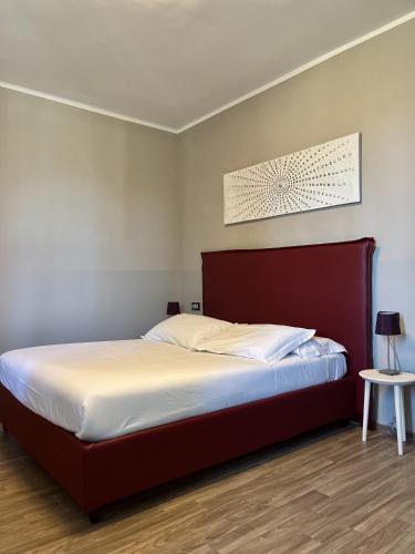 a bedroom with a large bed with a red headboard at Casa Caimotta in Neive