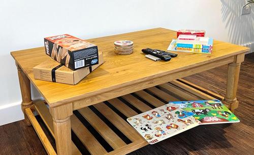 a wooden table with a remote control and books on it at Linwood in Lincoln