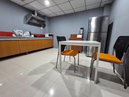 a kitchen with a table and chairs and a refrigerator at Chiangmai vibe, City House, 7 mins to BTS, City center, Private room in Sathon, Private bathroom, Bangkok, Thailand in Bangkok