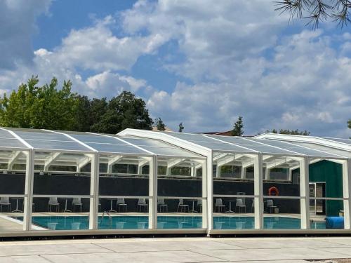 een gebouw met een zwembad met een dak bij El Vilar de la Duquessa By Duquessa Hotel Collection in Cardona