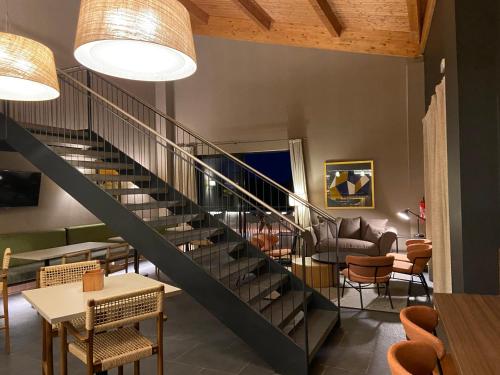een trap in een kamer met stoelen en tafels bij El Vilar de la Duquessa By Duquessa Hotel Collection in Cardona