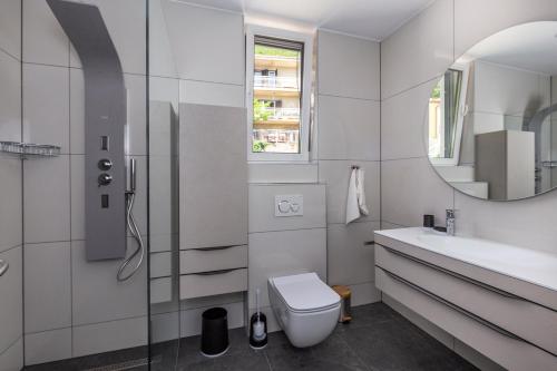 a bathroom with a toilet and a sink and a mirror at Villa Visum Mare Unus in Mošćenička Draga