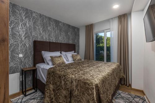 a bedroom with a bed with a bedspread and a window at Villa Visum Mare Unus in Mošćenička Draga