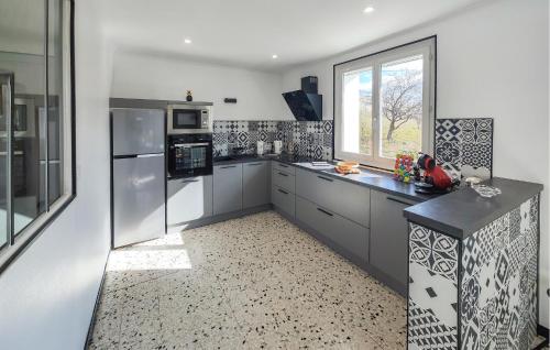 une grande cuisine avec des armoires blanches et une fenêtre dans l'établissement Confortable Maison Avec Vue, à Berlou