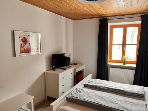 a bedroom with a bed and a tv and a window at Zum Zacherwirt in Hengersberg