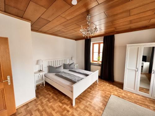 ヘンガースベルクにあるZum Zacherwirtの白いベッドと木製の天井が備わるベッドルーム1室が備わります。