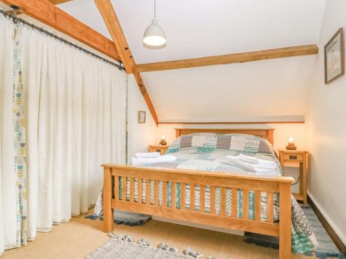 a bedroom with a wooden bed and a window at Braeburn - Uk38098 in Pilton