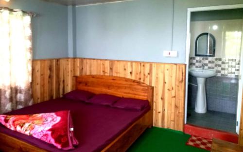 a bedroom with a wooden bed and a sink at Vedanta Homestay by StayApart in Mangpu
