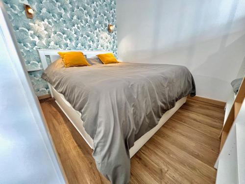 ein Schlafzimmer mit einem Bett mit zwei gelben Kissen in der Unterkunft AA P Terrasse de Stella in Nizza