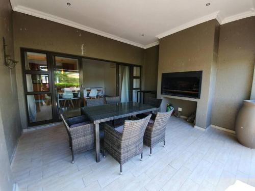 a dining room with a table and chairs at Modern Large 5 bedroom Villa in Pecanwood Golf Estate in Hartbeespoort