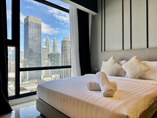 a bedroom with a bed with a view of a city at Axon Suites Kualalumpur in Kuala Lumpur