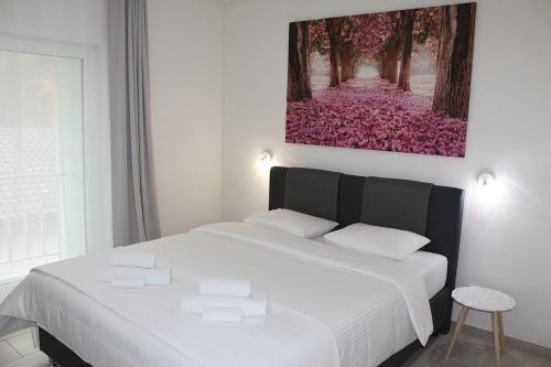 a bedroom with a white bed with a painting on the wall at REST AND RESTAURANT in Roveredo in Roveredo