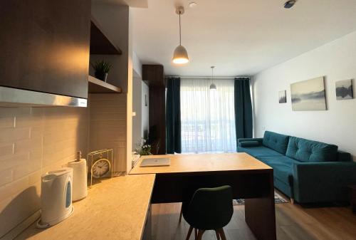 a living room with a blue couch and a table at Sinaia Walter 20 Apartment w Paid Pool and Free Parking in Sinaia