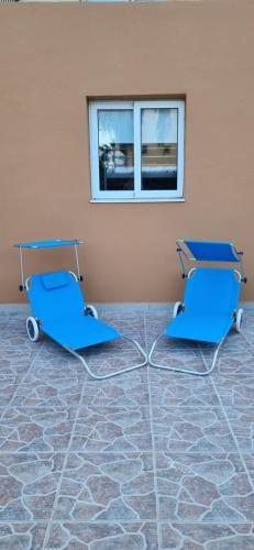 two blue chairs in a room with a window at Hermes Complex 2 Kappari Paralimni Cyprus in Paralimni