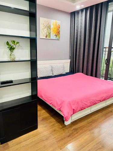 1 dormitorio con cama rosa y estante en Vinhomes Green Bay G30332, en Hanói