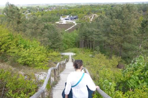 a woman walking down a wooden trail at Duinberk B&B hotel en Brasserie in Schoorl