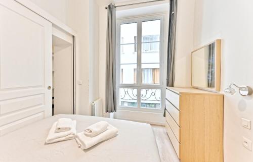 une chambre avec un lit et une fenêtre dans l'établissement Appartement au cœur du Marais - IV, à Paris
