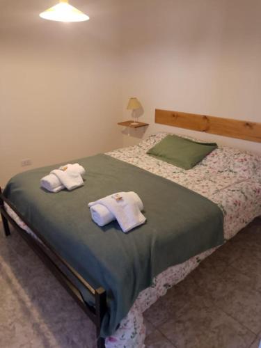 1 dormitorio con 1 cama con toallas en departamento equipado Pioneros en Zapala