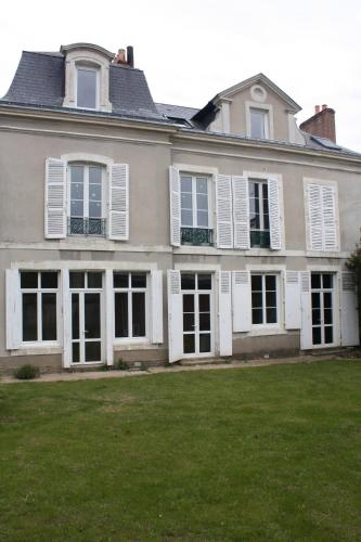 Casa grande con ventanas blancas con contraventanas y patio en 2 Chambres doubles en centre-ville du Mans, en Le Mans