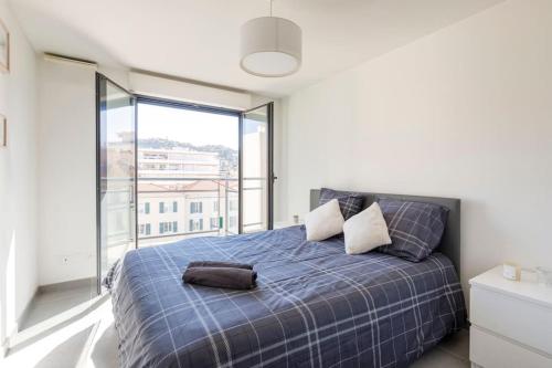 - une chambre avec un lit bleu et une grande fenêtre dans l'établissement Superbe T2 Moderne et Luxueux, à Cannes
