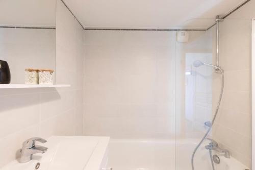 une salle de bain blanche avec une douche et un lavabo dans l'établissement Superbe T2 Moderne et Luxueux, à Cannes