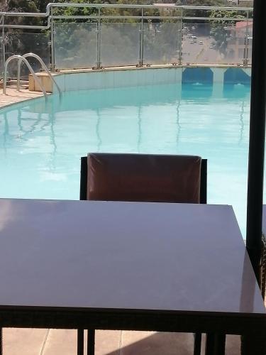 a table and chair in front of a swimming pool at Joy suites emeli in Nairobi