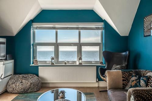 a living room with a couch and a window at Bay View - Private parking, beach views, central location in Kent