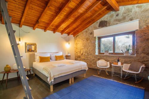 カステロ・デ・ヴィデにあるCasinhas da Póvoa- Turismo Naturezaの窓付きの部屋にベッド付きのベッドルーム1室があります。