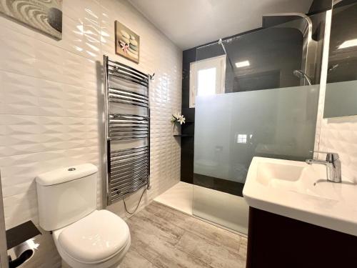 een witte badkamer met een toilet en een wastafel bij Chalet Hungría Chalet con piscina privada in Peñíscola