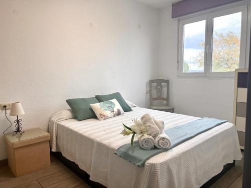 een slaapkamer met een bed met handdoeken en een raam bij Chalet Hungría Chalet con piscina privada in Peñíscola