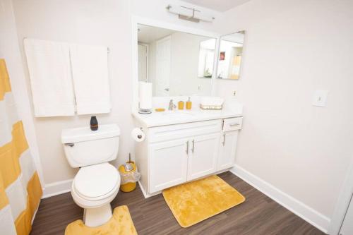 ein Badezimmer mit einem weißen WC und einem Spiegel in der Unterkunft Perfect Stay! 1 BR mins to DC in Arlington