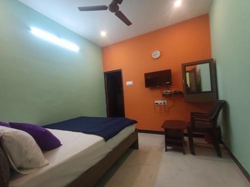 a bedroom with a bed and a table and a mirror at SD Residency - Yercaud in Yercaud