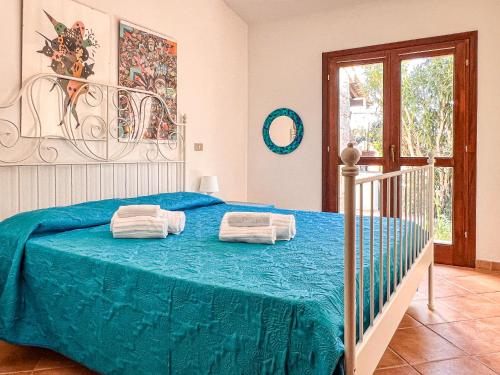 ein Schlafzimmer mit einem blauen Bett und Handtüchern darauf in der Unterkunft Villetta Gaia in Conca Verde