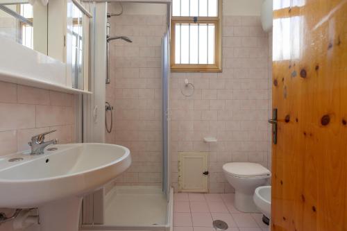 y baño con lavabo, ducha y aseo. en Villino Pamela by BarbarHouse, en Torre Lapillo