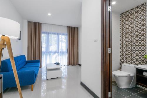 a living room with a blue chair and a window at Haka Boutique Hotel in Da Nang
