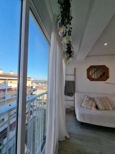 a room with a bed and a balcony with a window at Duplex OverTheTejo, 5 min Belém Tower in Lisbon