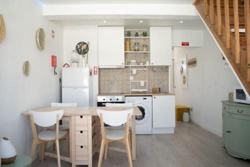 uma cozinha com uma mesa de madeira e electrodomésticos brancos em Duplex OverTheTejo, 5 min Belém Tower em Lisboa