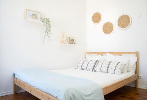 uma cama num quarto branco com dois espelhos na parede em Duplex OverTheTejo, 5 min Belém Tower em Lisboa