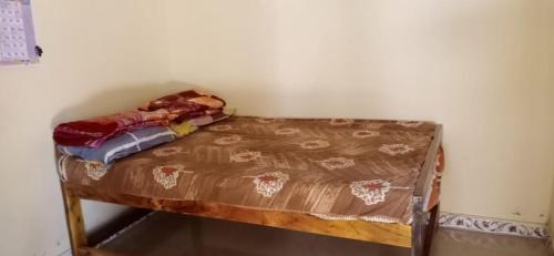 Cama pequeña en una esquina de habitación en Om Laxmi Narayan Homestay, en Diveagar