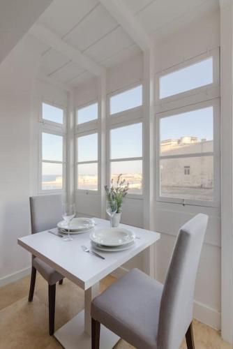 - une salle à manger blanche avec une table et des chaises blanches dans l'établissement Rare Seaview Condo in Valletta 2, à La Valette