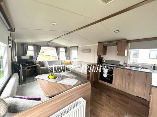 an rv living room with a table and a kitchen at Seton Sands Holiday Village Klover in Port Seton