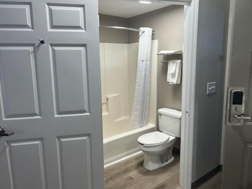 W łazience znajduje się biała toaleta i prysznic. w obiekcie Baymont by Wyndham Lakeland w mieście Lakeland